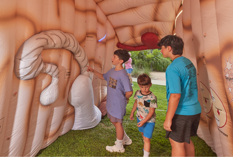 Students tour the inside of a giant inflatable brain at a school health fair.