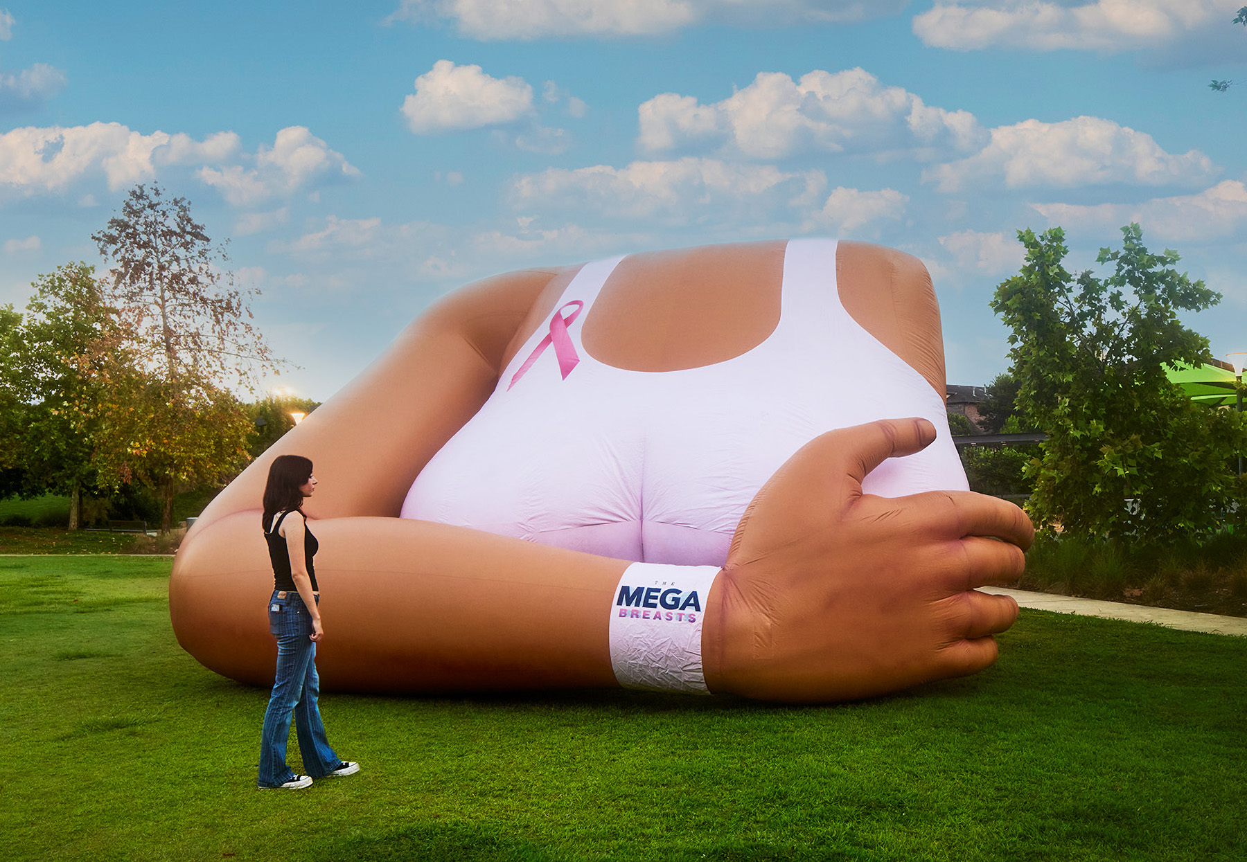 A woman standing in front of a large inflatable woman's torso.